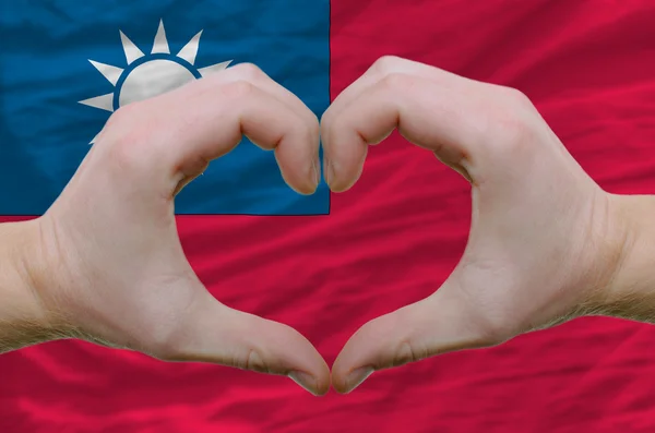 Жест любви и сердца, показанный руками над флагом Тайваня — стоковое фото