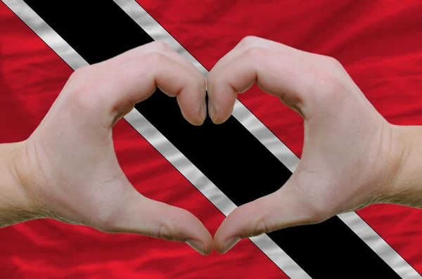 Srdce a lásku gestem ukázal rukou nad vlajkou trinidad tob — Stock fotografie
