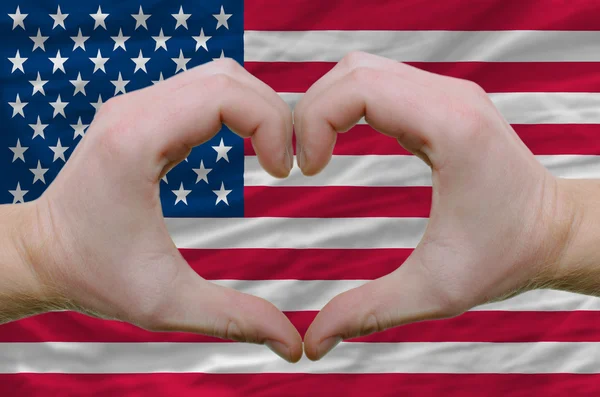 Coração e amor gesto mostrado por mãos sobre bandeira dos EUA backgrou — Fotografia de Stock