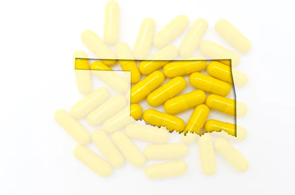 Outline map of oklahoma with transparent pills in the background — Stock Photo, Image