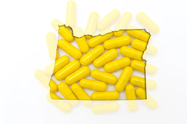 Mapa do contorno de Oregon com pílulas transparentes em segundo plano — Fotografia de Stock