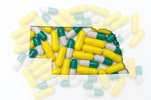Konturkarta över nebraska med transparent piller i bakgrunden — Stockfoto