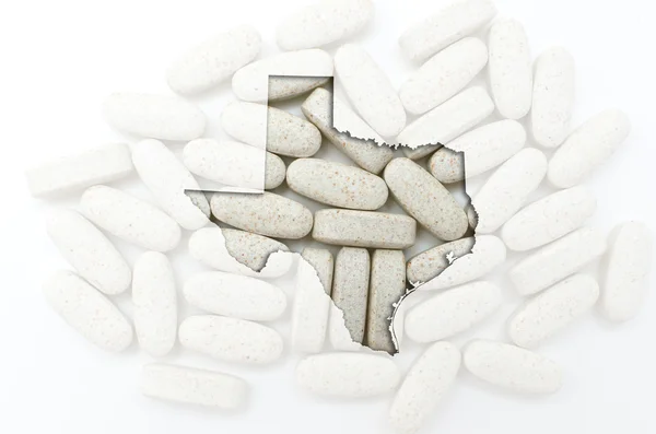 Outline map of texas with transparent pills in the background — Stock Photo, Image
