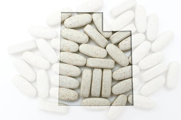 Umrisskarte von utah mit transparenten Pillen im Hintergrund — Stockfoto