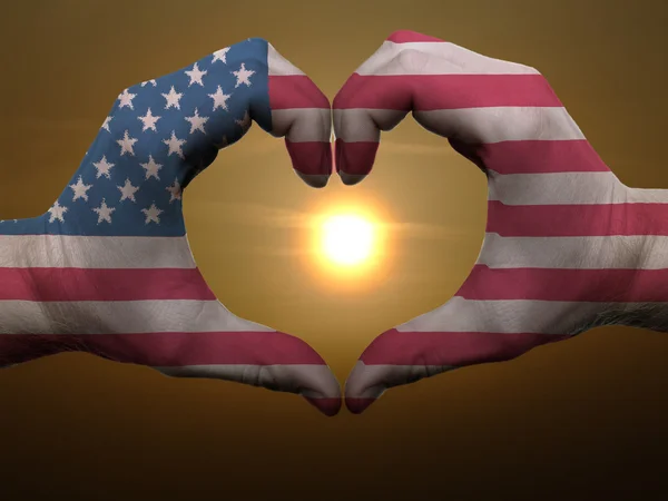 Heart and love gesture by hands colored in american flag during — Stock Photo, Image