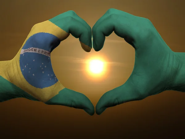 Cœur et geste d'amour par les mains colorées dans le drapeau brésilien pendant être — Photo