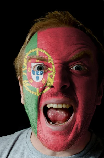 Лицо безумного злого человека, раскрашенного в цвета португальского флага — стоковое фото