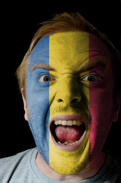 Gesicht des verrückten wütenden Mannes in den Farben der rumänischen Flagge gemalt — Stockfoto