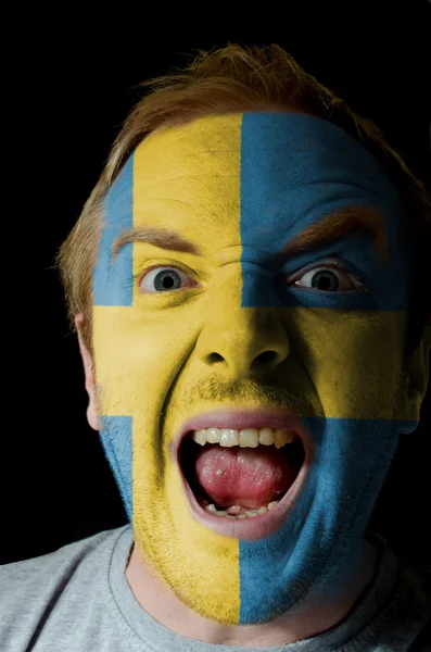 Rosto de homem furioso louco pintado em cores da bandeira da Suécia — Fotografia de Stock