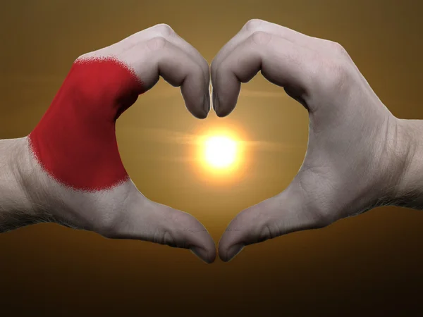 Жест любви и сердца руками, раскрашенными в японский флаг во время боа — стоковое фото