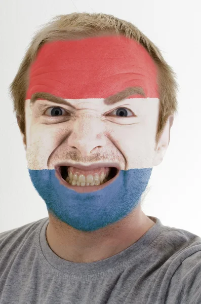 Hollanda bayrağı renklerde boyanmış deli kızgın adamın yüzü — Stok fotoğraf