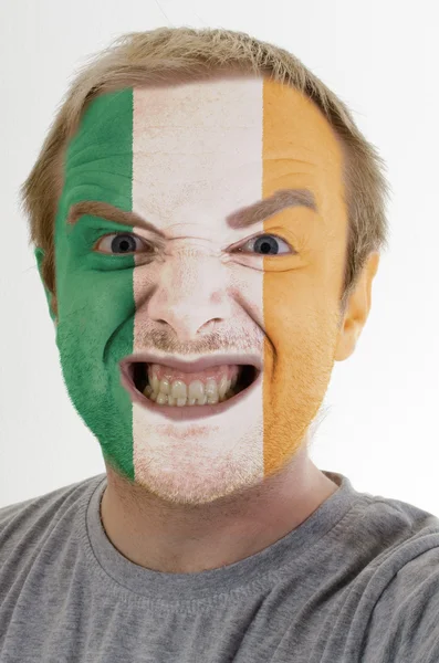 Face of crazy angry man painted in colors of ireland flag — Stock Photo, Image