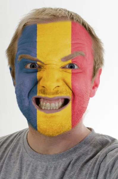 Лицо безумного злобного человека, раскрашенного в цвета флага Румынии — стоковое фото