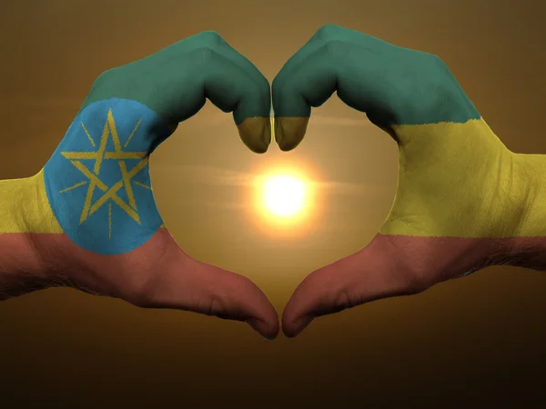 Жест любви и сердца руками, раскрашенными в флаг Эфиопии во время — стоковое фото