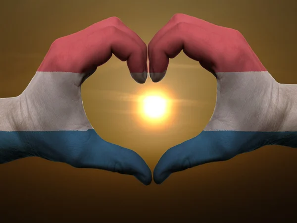 Heart and love gesture by hands colored in holland flag during b — Stock Photo, Image