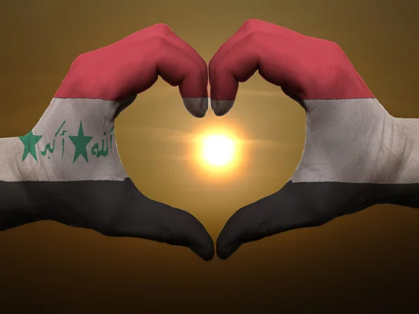 Corazón y gesto de amor con las manos coloreadas en la bandera iraq durante el beau —  Fotos de Stock