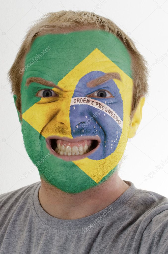 Face of crazy angry man painted in colors of brazil flag