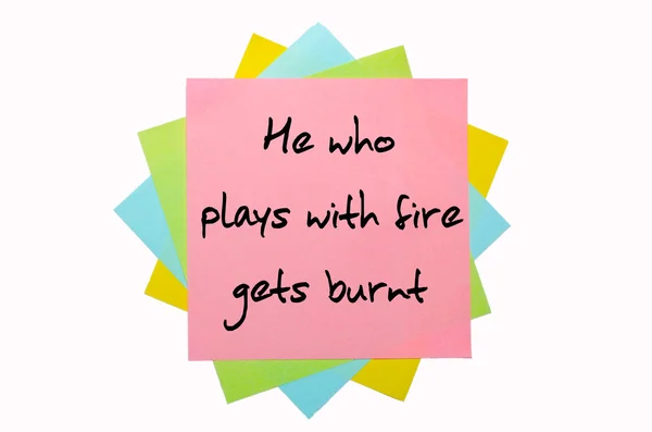 Proverb " He who plays with fire gets burnt " written on bunch o — Stock Photo, Image