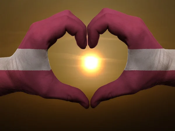 Corazón y el amor gesto por las manos de color en la bandera de latvia durante ser — Foto de Stock