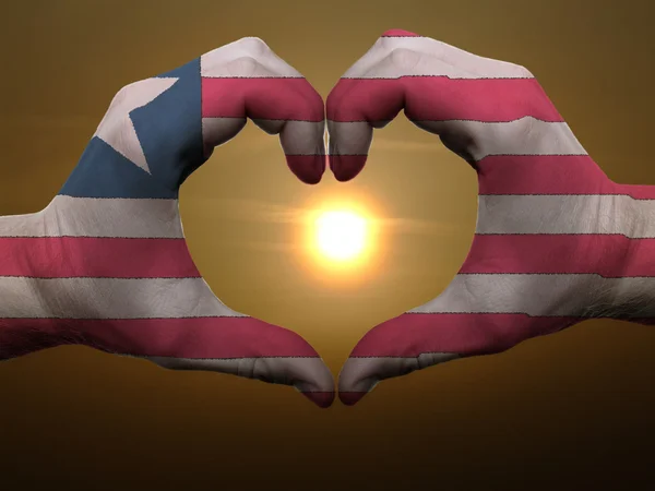 Heart and love gesture by hands colored in liberia flag during b — Stock Photo, Image