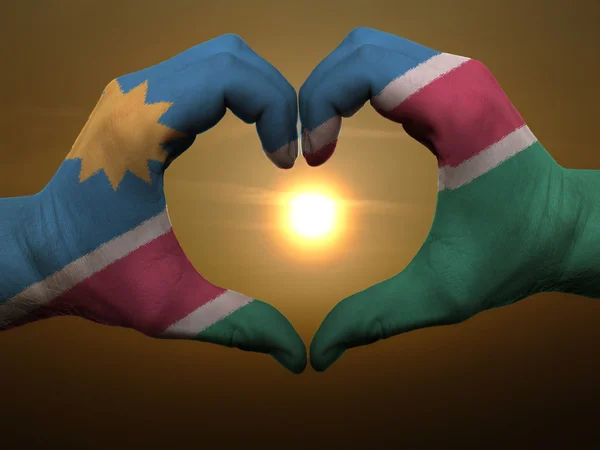Heart and love gesture by hands colored in namibia flag during b — Stock Photo, Image