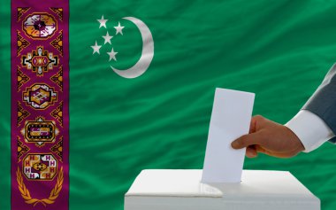 Man voting on elections in turkmenistan in front of flag clipart