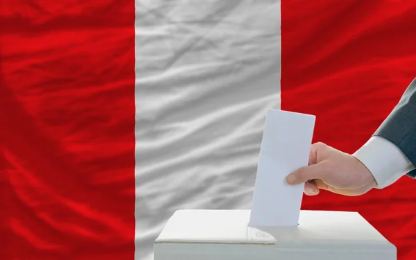 Homem votando nas eleições no peru em frente à bandeira — Fotografia de Stock