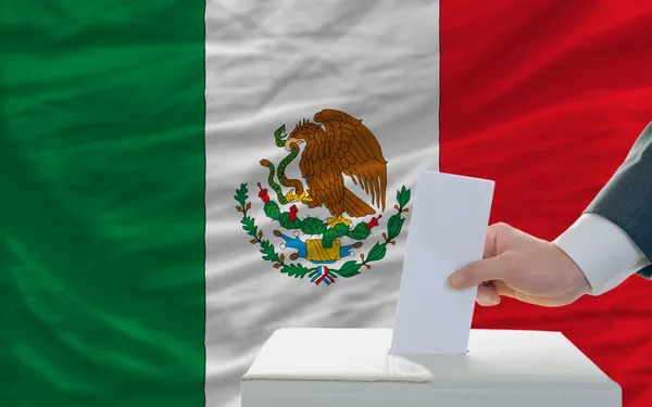 Man voting on elections in mexico in front of flag — Stock Photo, Image