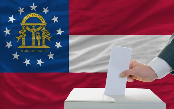 Man röstar om valet i Georgien framför flagga — Stockfoto