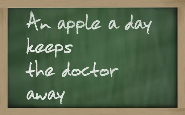 " Uma maçã por dia mantém o médico longe "escrito em um quadro negro — Fotografia de Stock