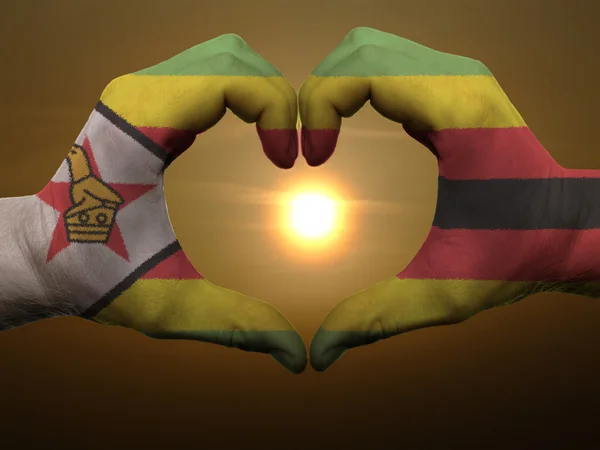 Heart and love gesture by hands colored in zimbabwe flag during — Stock Photo, Image