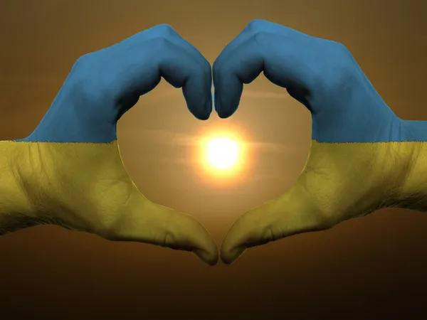 Coração e amor gesto por mãos coloridas em bandeira ucraniana durante b — Fotografia de Stock