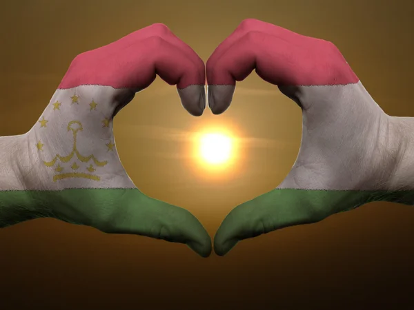 Cœur et geste d'amour par les mains colorées dans le drapeau du tadjikistan durin — Photo