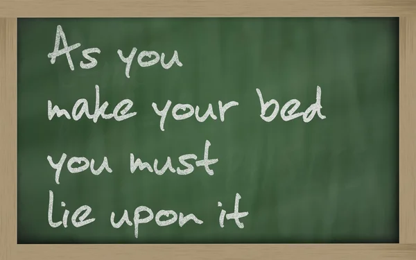 " As you make your bed you must lie upon it " written on a black — Stock Photo, Image