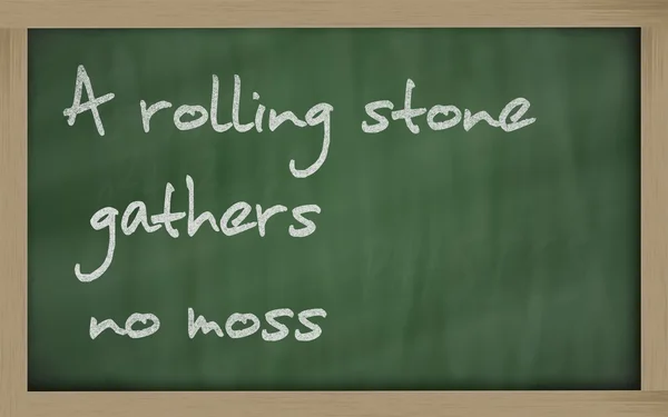 " ein rollender Stein sammelt kein Moos "steht auf einer Tafel geschrieben — Stockfoto