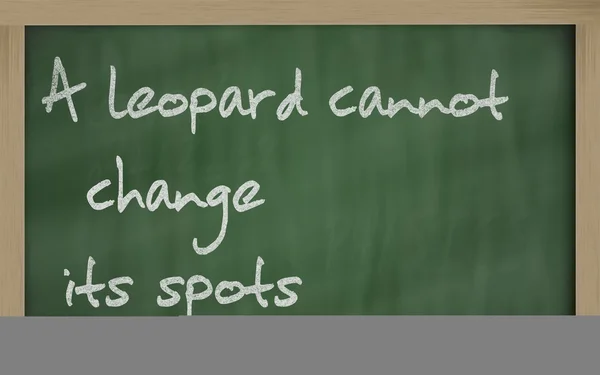 " 豹子不能改变它的位置"写在黑板上 — 图库照片