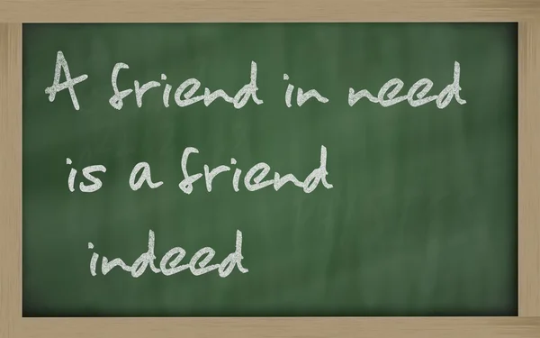 " 需要帮助的朋友确实是一个朋友"写在黑板上 — 图库照片