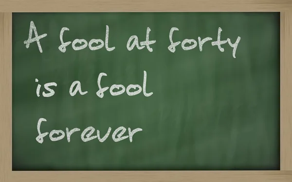 " A fool at forty is a fool forever " written on a blackboard — Stock Photo, Image