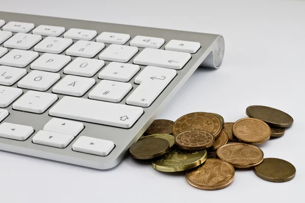 Computer keyboard with white keys and coins — Stock Photo, Image