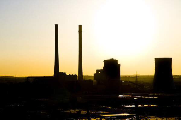 Sunset over coal-fired power plant with two moke stacks