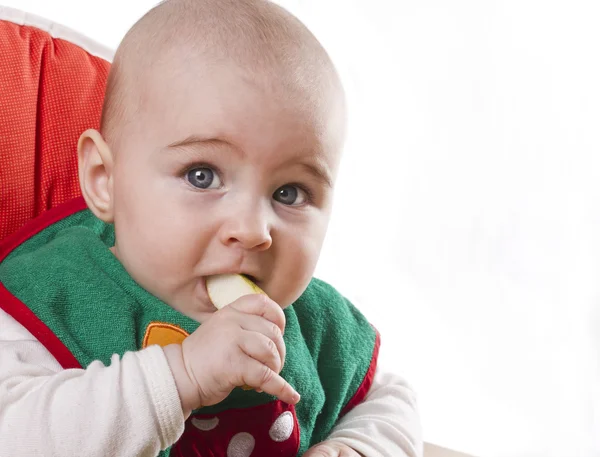 Baby sitting and eating an apple — Stock Photo, Image