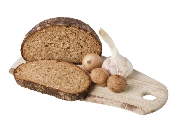 Brown bread on shelf with onion, garlic and walnut — Stock Photo, Image