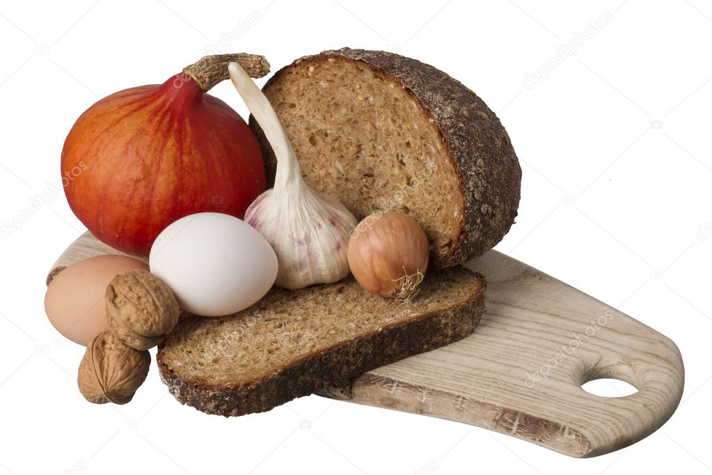 Brown bread on shelf with onion, garlic and walnut