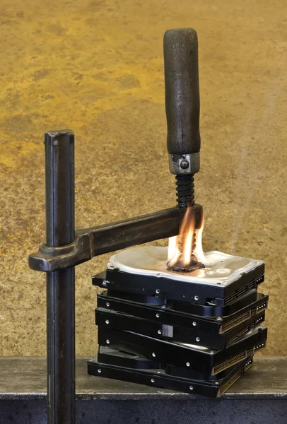 Clamp pressing on burning stack of hard drives — Stock Photo, Image