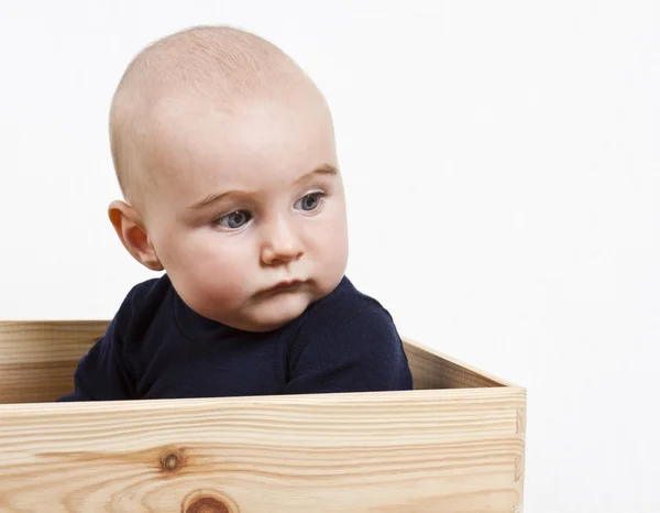 Kisgyermek fadobozban — Stock Fotó