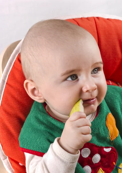 Barnet sitter och äta ett äpple — Stockfoto