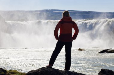 Woman Hiker Stnding In Front Of a Huge Waterfall clipart