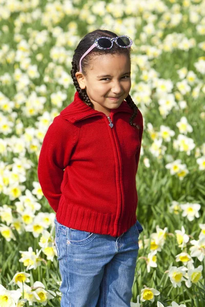 Menina brincando em Daffodils — Fotografia de Stock