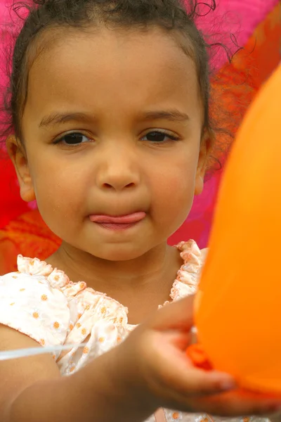 Mladé smíšené rasy dítě drží balónky na večírku — Stock fotografie