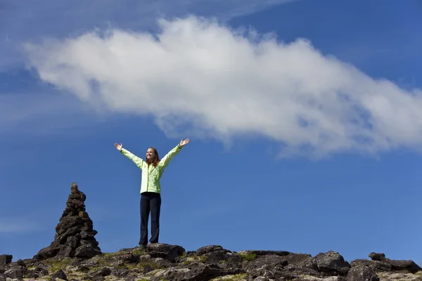 Женщина празднует достижение на вершине горы — стоковое фото